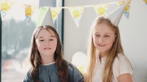 Two Cheerful Girls Celebrate Birthday Indoors