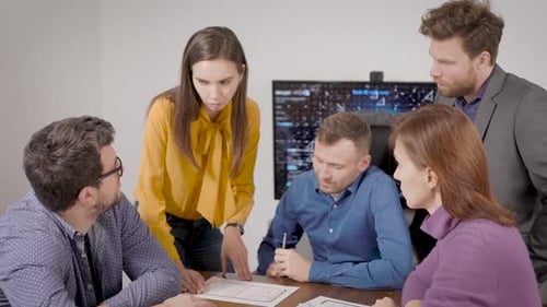 Team of Male and Female Experts Are Discussing and Examining Papers in Office Room at Work Meeting