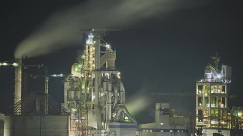 Timelapse of Illuminated Cement Plant with High Factory Structure and Tower Cranes at Industrial