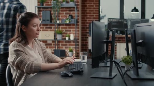 Software Engineer Typing Source Code on Computer Keyboard Turning Head and Smiling