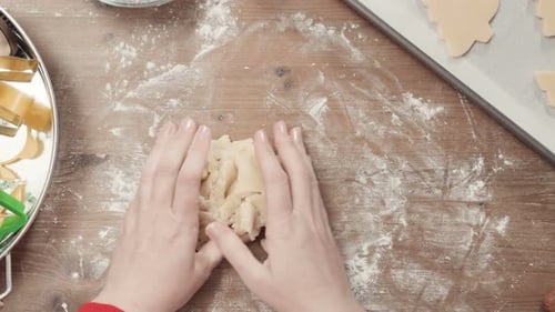 Woman Rolling Christmas Cookie Dough on Wooden Table
