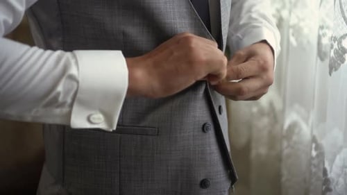 Man Buttons Grey Vest Before Formal Occasion