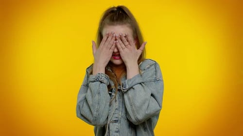 Étudiante fille dans une veste en jean fermant les yeux montrant un geste d'arrêt confuse timide peur de regarder