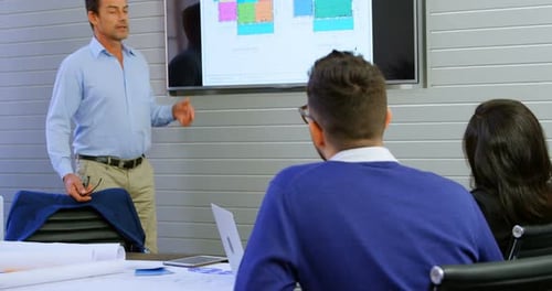 Architect Presenting Building Plans to Colleagues