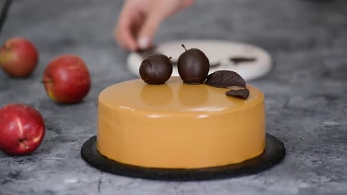 Pastry Chef Decorating the Cake with Chocolate Apples and Leaves. Pastry Chef Decorated Modern