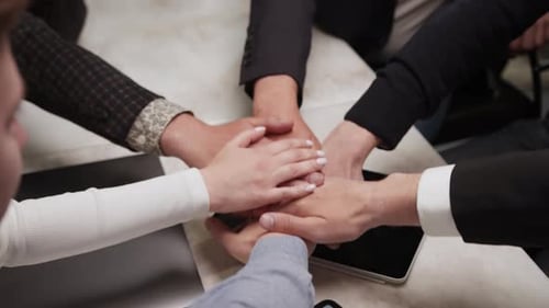 Close up top view of young business people putting their hands together. Stack of hands