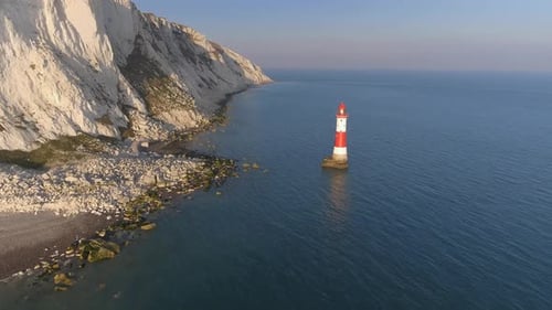 Luftaufnahme eines Leuchtturms im Meer bei Sonnenuntergang