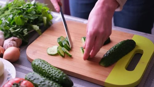 Cucumber Being Cut on Wooden Cutting Board