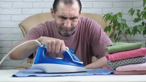 Man ironing clothes at home