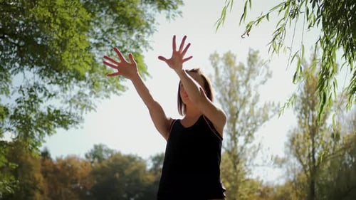 The Girl Performs Warmup Exercises Before Yoga in Nature n Park