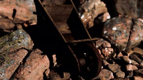 Abandoned Wooden Mine Wheelbarrow on Rocks