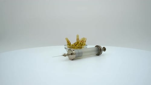 Syringe and Medicine Vials on White Surface