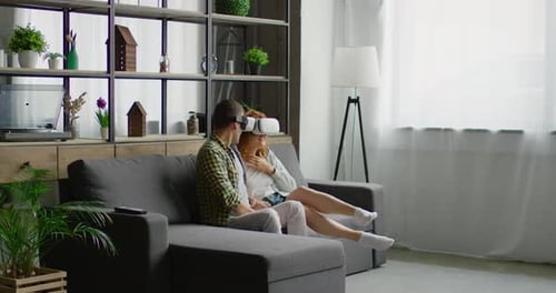 Couple Experiencing Virtual Reality Together on Couch