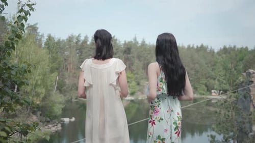 Portrait Two Charming Young Women Wear Summer Dresses Standing in the Top of Rock