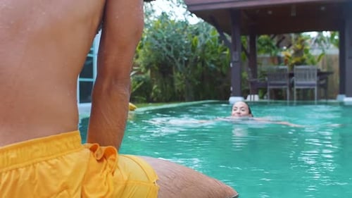 Woman Swimming, Man Kissing in Tropical Swimming Pool