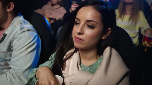 Happy Woman Watching Movie in Cinema. Smiling Girl Eating in Movie Theater.