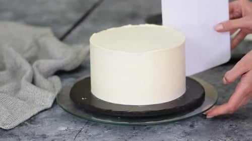 Chef Decorating a Delicious Cake with White Frosting