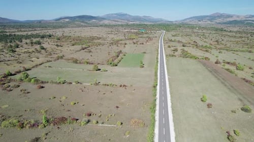 Empty Asphalt Road on the Plateau Between Green Fields Highland Way Aerial View