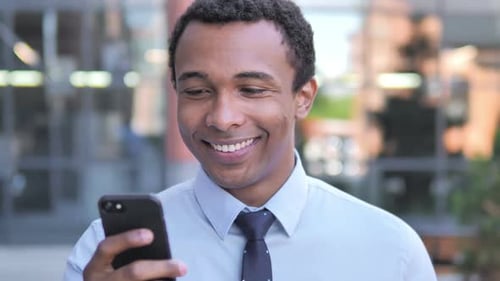 Smiling Man Using Cell Phone in Urban Setting