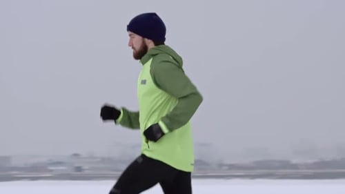 Man Jogging Through Snow in Winter Weather