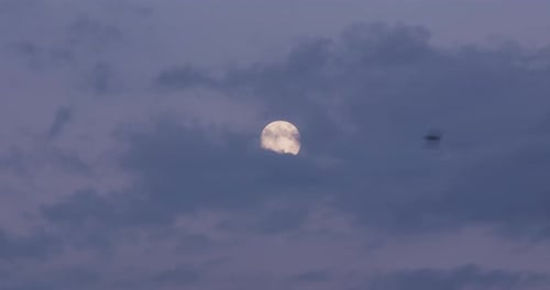 Full Moon shines through Clouds at Night
