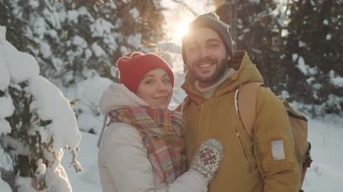 Portrait d'un couple heureux dans une forêt d'hiver