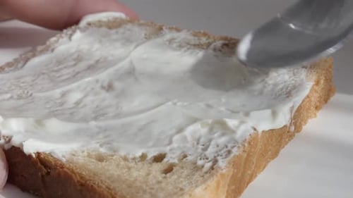 Spreading Cream Cheese on Wheat Bread