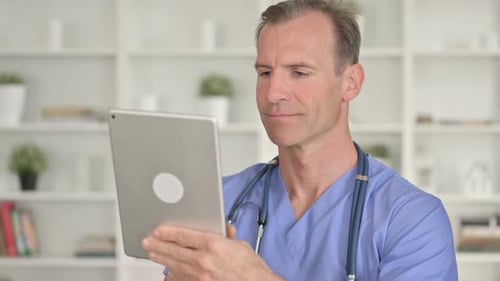 Porträt eines ernsthaften Arztes mittleren Alters mit Tablet