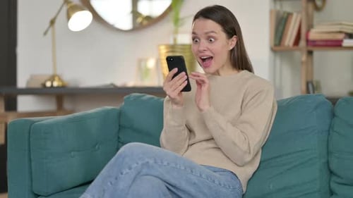 Excited Woman Celebrates News on Her Phone