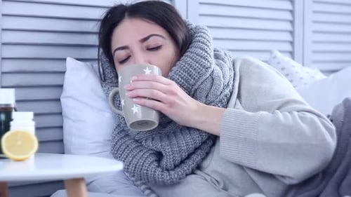 Woman Resting in Bed with Flu Symptoms