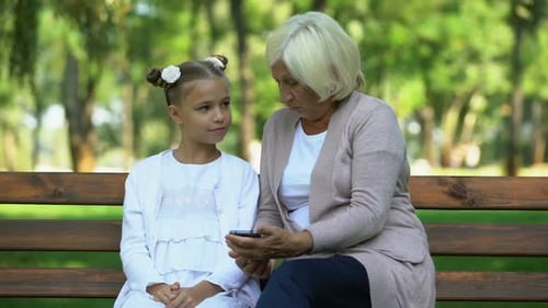 Cute Granddaughter Teaching Granny How to Use Modern Smartphone, Generation Gap