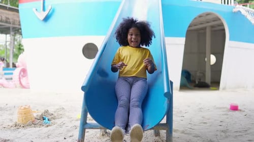 4K Little African girl sliding and playing at playground in the park