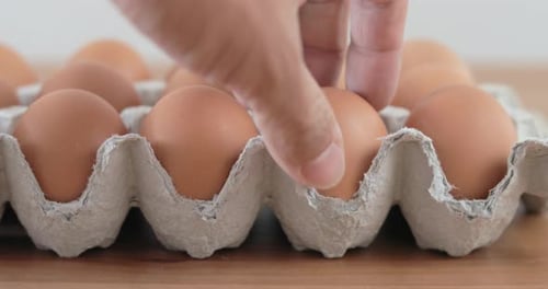 Eier von Hand aus der Packung pflücken