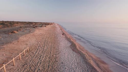 Young runner man training on beautiful sunset at beach