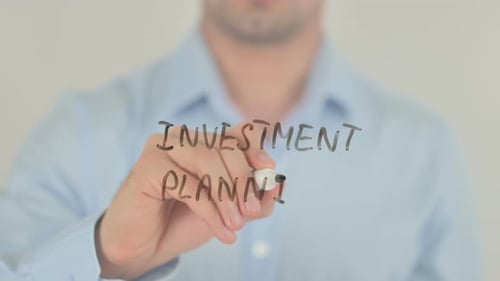 Man Writes Investment Planning on Clear Surface