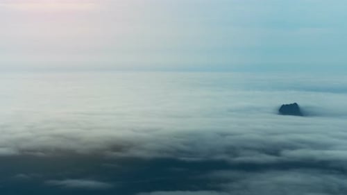 Mountain Peak Emerging from White Cloudscape