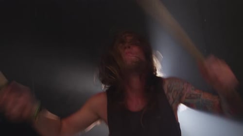 Man playing drums in heavy metal rock band, slow motion