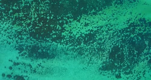 Daytime birds eye abstract shot of a sandy white paradise beach and aqua turquoise water background