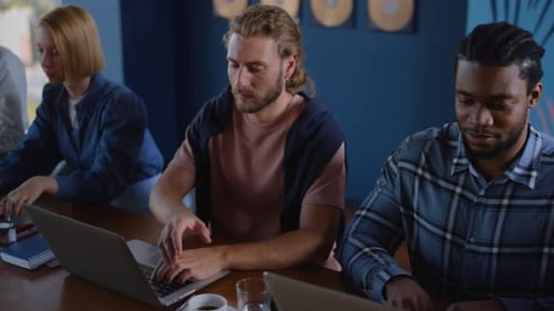 Enthusiastic Business Team Working at Laptops in Office