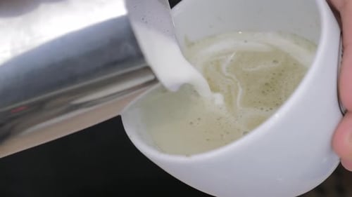 Foam Pouring Into Matcha Latte Cup Close Up