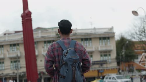Backpacker Photographs Urban City Architecture on Overcast Day