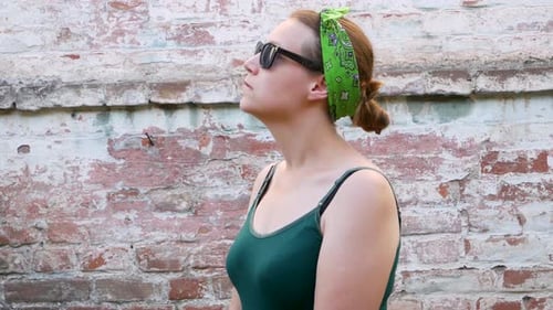 Young Woman Sneeze Due to Allergies Against Brick Wall