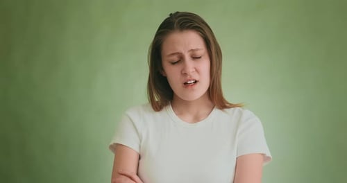 Disappointed Woman Shakes Head Posing for Camera on Green