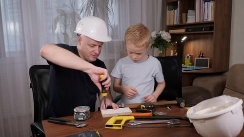 Man Helping Child Using Screwdriver on Wood