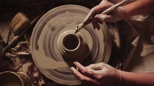 Jeune femme Potter travaillant avec une argile humide travaillant un bâton