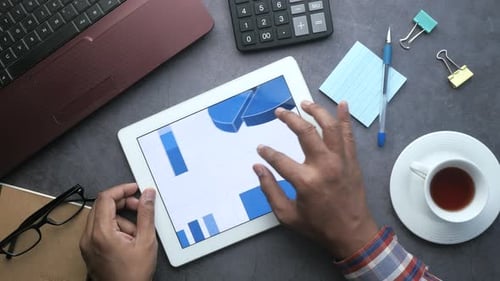 Businessman Analyzing Bar Chart on Digital Tablet