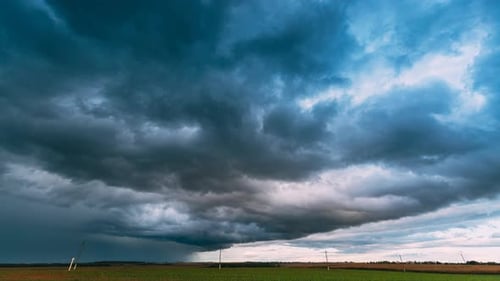 Dramatic Sky Before Rain With Rain Clouds On Horizon Above Rural Landscape Field Meadow