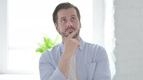 Man Touching Chin While Thinking Indoors