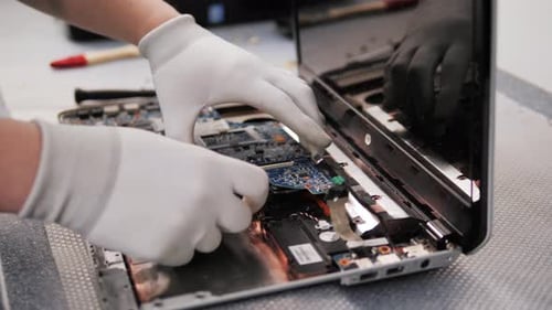 Closeup Shot of Male Hands Working on Disassembling and Cleaning Circuit Board in Laptop Using Brush