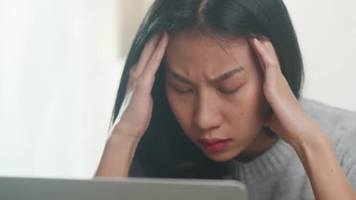 Stressed Woman Using Laptop Computer at Home